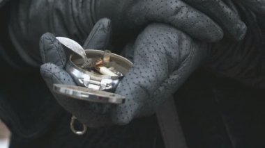 Siyah eldiven giymiş kadın sigara içiyor