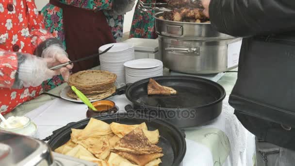 De verkoopster verkoopt traditionele Russische pannenkoeken — Stockvideo