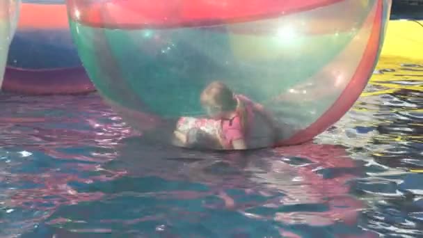 Niña dentro de una gran bola inflable en el agua — Vídeos de Stock