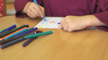 Çocuk Keçeli Kalemler kullanarak resim çizer