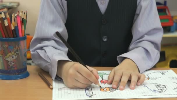 Το παιδί αντλεί τις εικόνες στο σημειωματάριο χρησιμοποιώντας μολύβια — Αρχείο Βίντεο