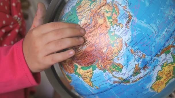Kind verdreht Modell der Weltkugel. Nahaufnahme — Stockvideo