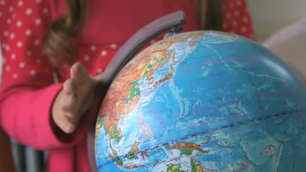 Child twists model of globe of world. Close-up — Stock Video