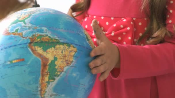 A menina gira o globo do mundo. Close-up — Vídeo de Stock