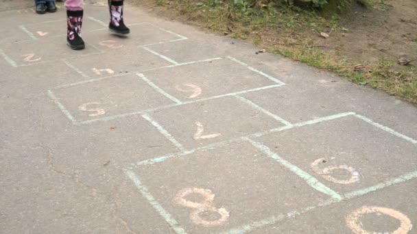 Criança jogando hopscotch ao ar livre — Vídeo de Stock