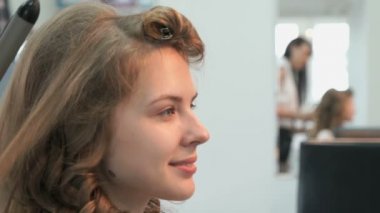 Profesyonel kuaför saç modeli bir kız için yapar.