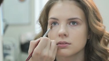 Genç manken için makyaj yapma makyaj sanatçısı