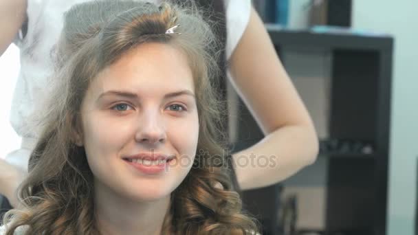 Peluquería peinando el cabello de una hermosa modelo — Vídeos de Stock