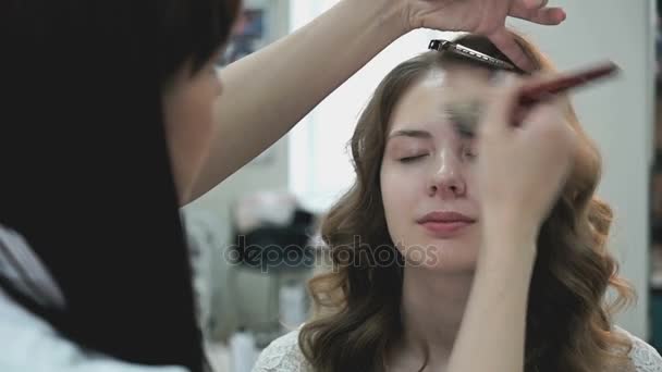 Макияж художник применить макияж до молодой девушки — стоковое видео