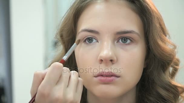 Maquillaje artista aplicar maquillaje a chica joven — Vídeos de Stock