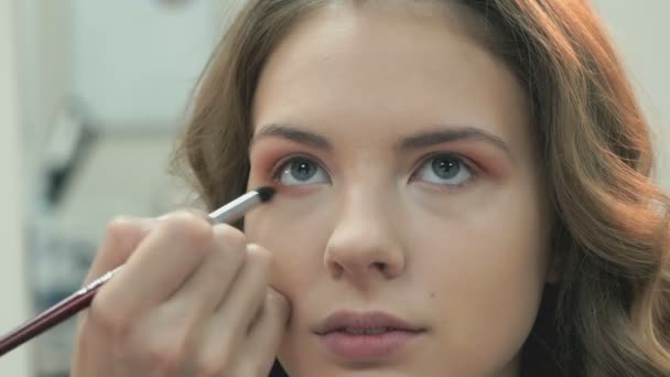 Создание профессионального макияжа для красивой девушки — стоковое видео
