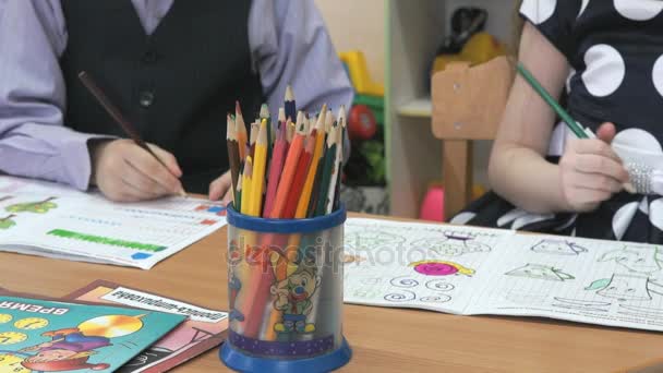 Kinderen tekenen beelden in notitieboekjes met behulp van potloden — Stockvideo