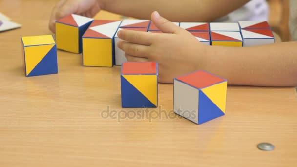 Child collecting a pattern using colored cubes — Stock Video