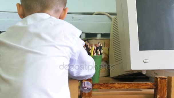 Mały chłopiec w komputerze klasy siedzi i studiyng — Wideo stockowe