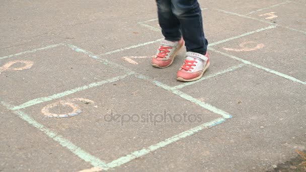 Niño jugando al hopscotch al aire libre — Vídeo de stock