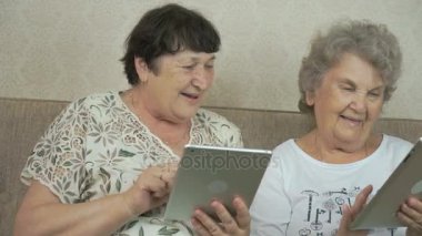 İki yaşlı kadın gümüş dijital tablet holding