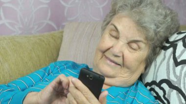 Cep telefonu kullanan yaşlı bir kadın.