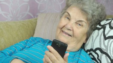 Bir akıllı telefon kullanan yaşlı kadın