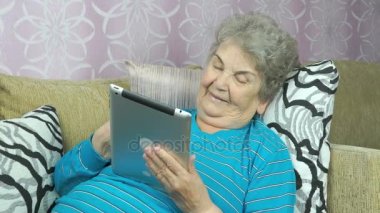 Gülümseyen kıdemli kadın üzerinde otel odası kanepe yatıyor