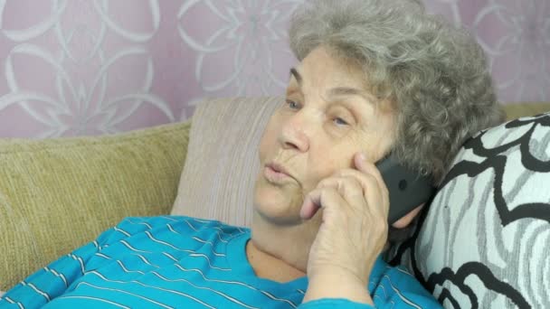 Senior woman with smartphone calling at room — Stock Video