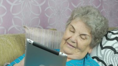 Üst düzey büyükanne bir tablet bilgisayar kapalı tutan