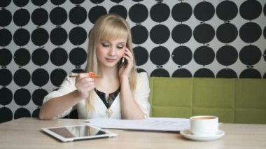 Cep telefonu üzerinde konuşurken bir kafede oturan kız