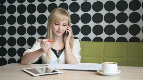女孩坐在一家咖啡馆谈移动电话 — 图库视频影像