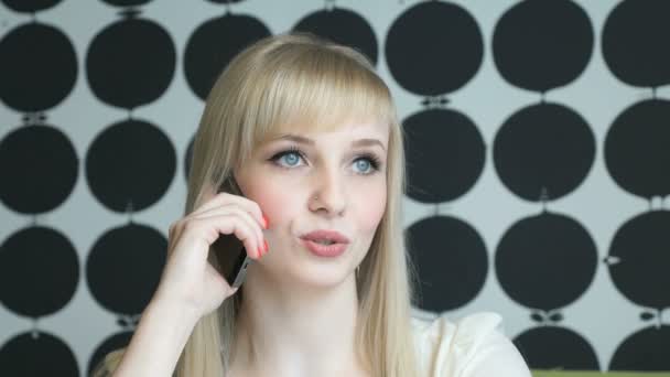 Dívka sedí v kavárně rozhovory na mobilním telefonu — Stock video