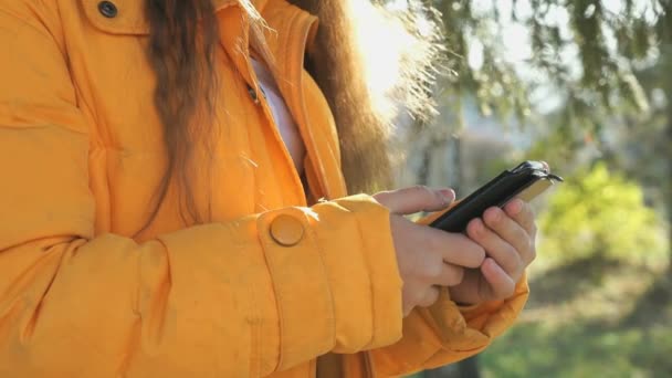 Chica de la escuela ve sus fotos usando un teléfono inteligente — Vídeos de Stock