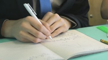 Kapalı okul masasında oturan genç