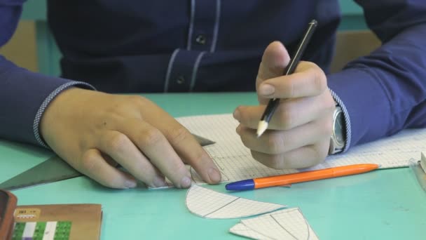 Eleven bestämmer sig uppgiften i en anteckningsbok i matematik — Stockvideo