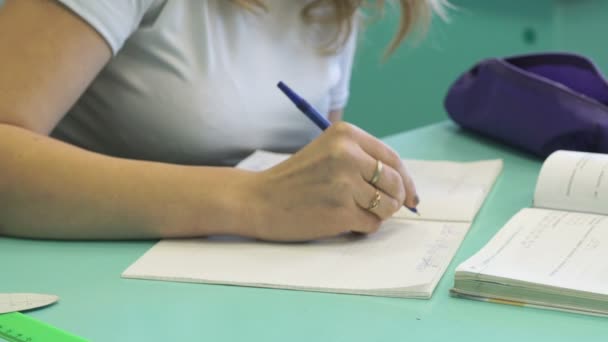 Tiener schrijft in beurt bij de les — Stockvideo