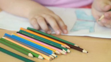 Çocuk resimleri defterini çizer.