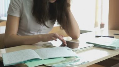 Kız bir gümüş bilgisayar tablet kullanarak metni okur