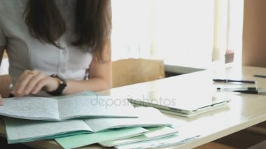 Masada oturan kız için defterini görünüyor