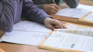 Okul çocuğu metni defterini kapalı yazıyor.