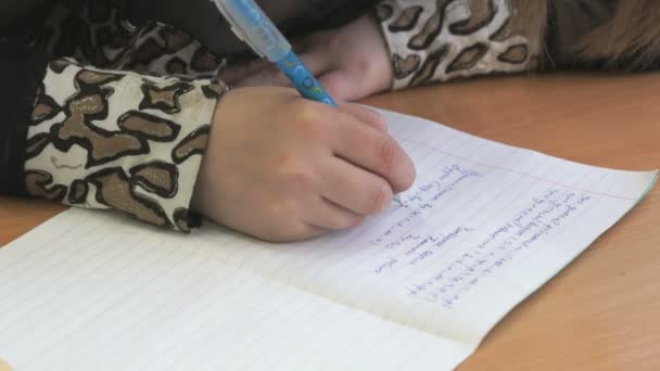 Schoolmeisje schrijft de tekst in de beurt met een pen — Stockvideo