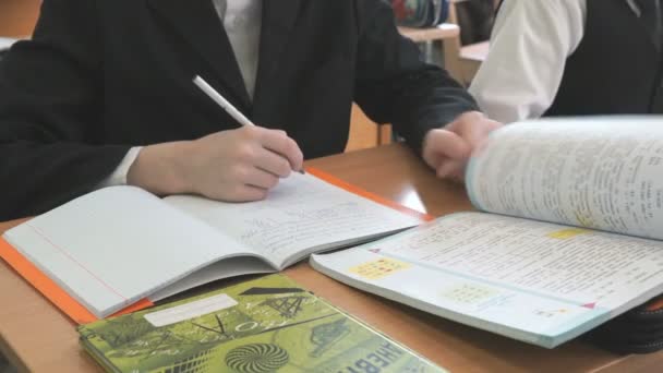 Leerling klapt pagina's van leerboek tijdens de les — Stockvideo