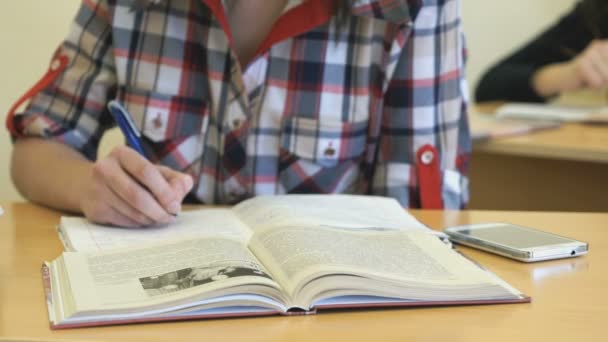 Schoolgirl écrit le texte dans le copybook — Video