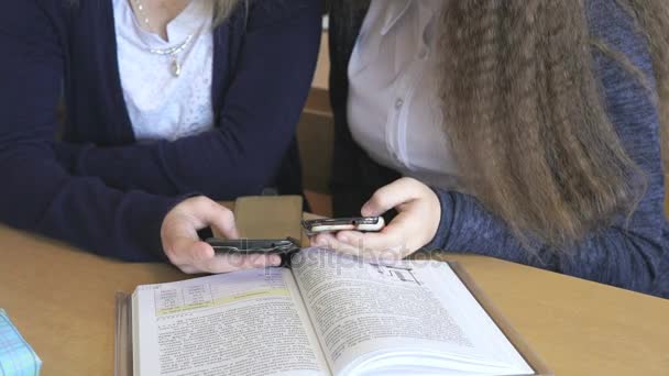Ученик смотрит на фотографии с помощью мобильного телефона — стоковое видео