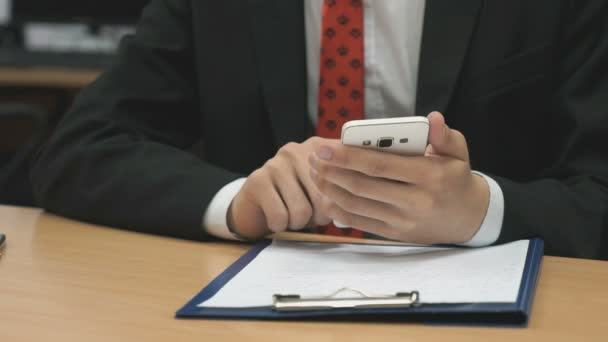 Man vergadering schrijven de tekst met behulp van de smartphone — Stockvideo