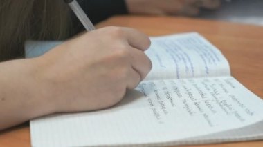 Öğrenci ders içinde defterini yazıyor