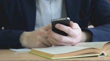Öğrenci bir smartphone kullanarak metni yazar