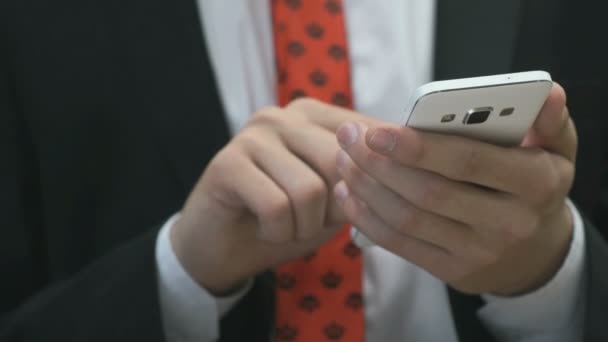 Homem segurando o telefone celular branco dentro de casa — Vídeo de Stock