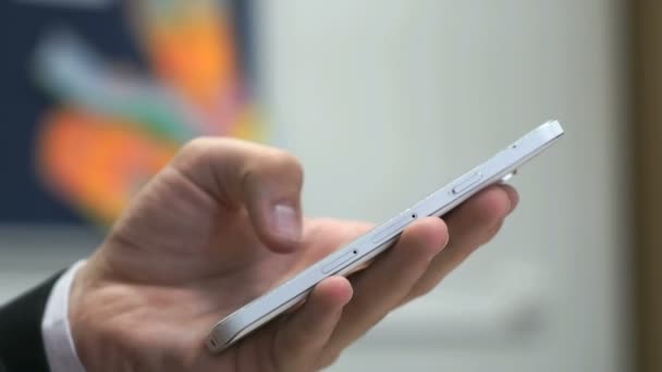 Uomo che tiene il cellulare bianco al chiuso — Video Stock