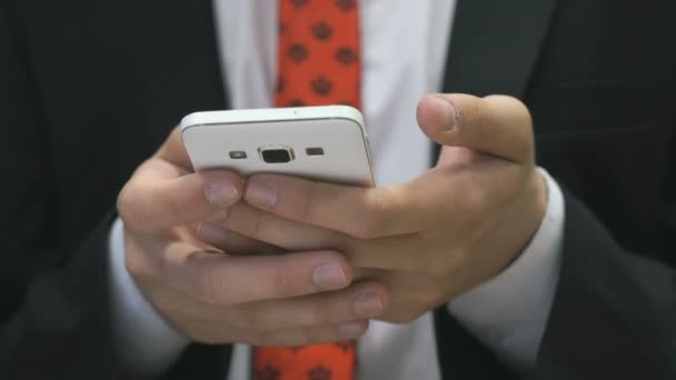 Άνθρωπος που κρατά το λευκό κινητό τηλέφωνο σε εσωτερικούς χώρους — Αρχείο Βίντεο