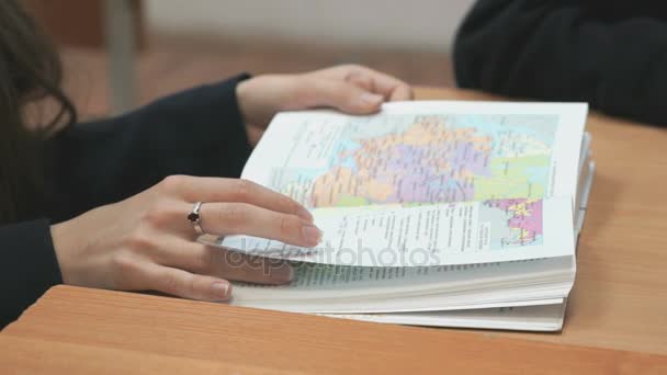 Colegiala voltea páginas de libro de texto de la escuela en el interior — Vídeo de stock