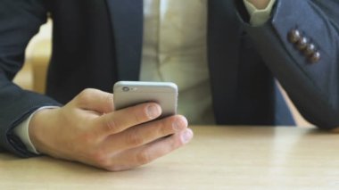 Çocuk bir smartphone kullanarak metni yazar