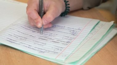 Sınıfta bir defter Schoogirl yazıyor
