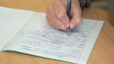 Bir defter sınıfta öğrenci yazıyor